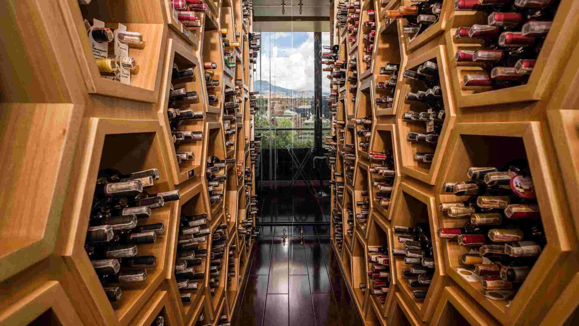  interior de una moderna cava, dividida en dos y repleta de botellas.