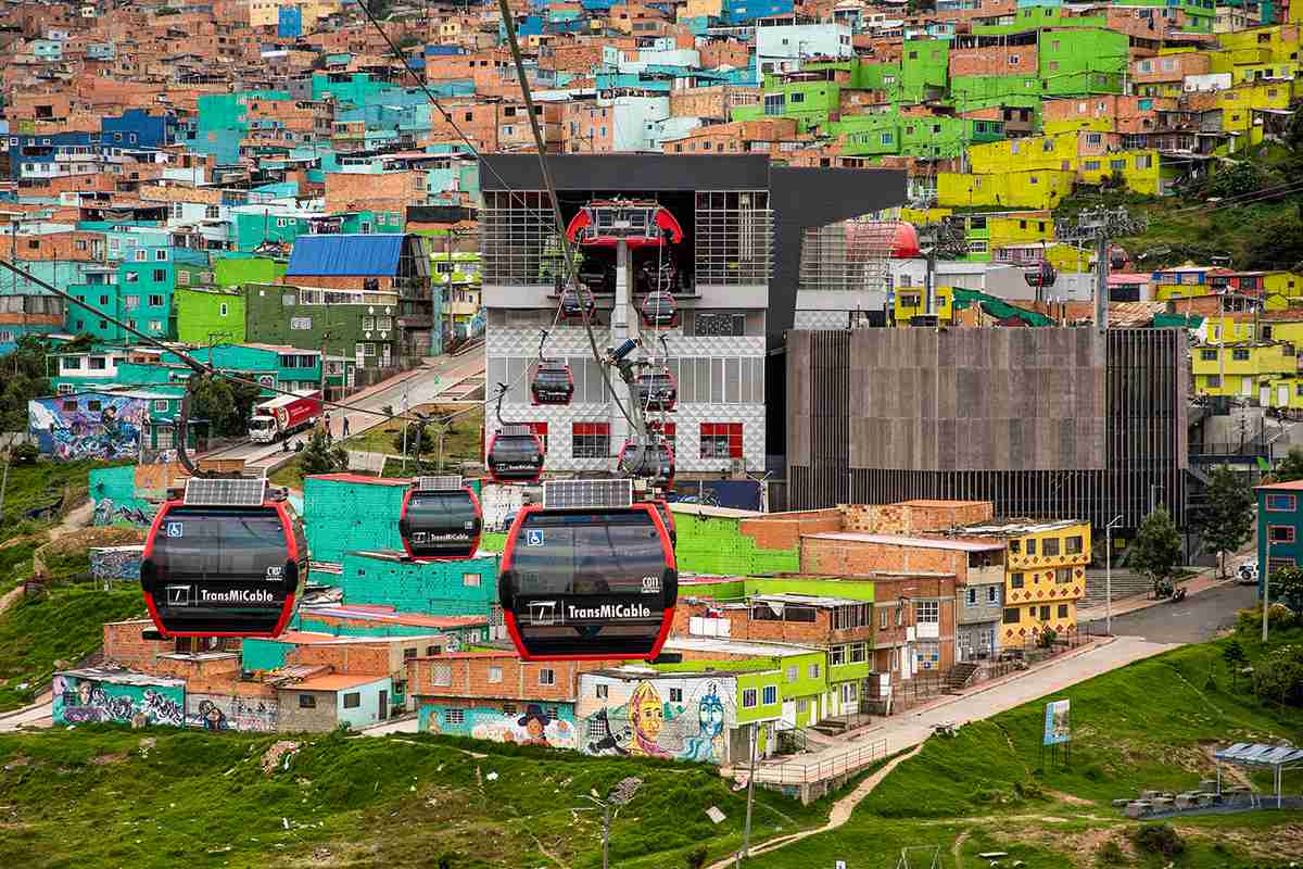 A cable car climbs a hill surrounded by colorful buildings, creating a vibrant and picturesque landscape