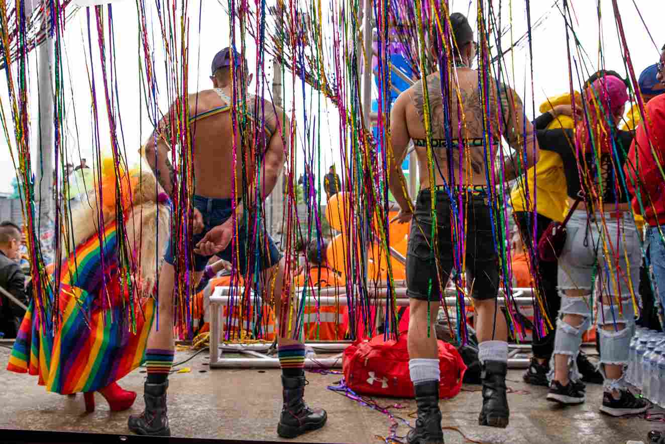 Dos hombres con el torso desnudo bailan en una tarima