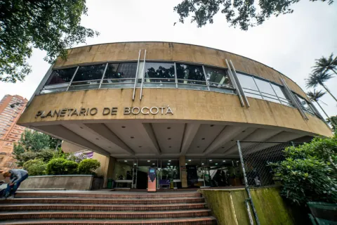 Yellow plaque facade with windows displaying the title "Bogotá Planetarium"
