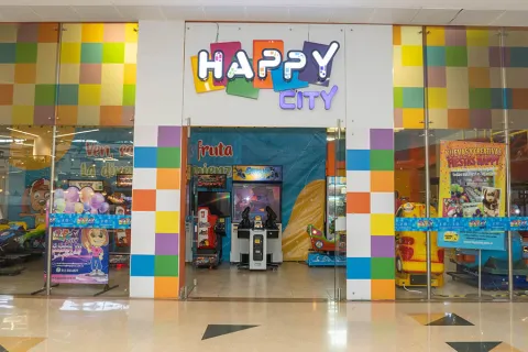 The storefront, painted in various colors, prominently features a sign that reads: "Happy City"