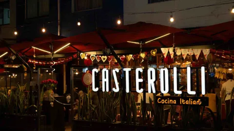 Vista exterior nocturna del restaurante Casterolli, iluminado con luces cálidas y decoración festiva.