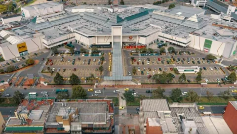 Plano general de la fachada de una gran zona de edificaciones de mediana altura, con una amplia área de parqueaderos.