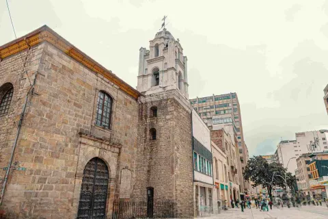 Side view of the church's facade. Some people can be seen in the street in the background.