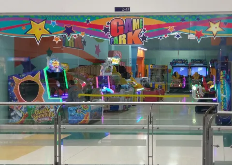 Área de juegos infantil dentro de “Game Park”, con máquinas interactivas, juegos temáticos y pequeños vehículos de entretenimiento.