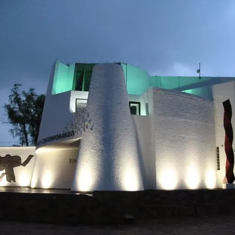 Edificio del Museo de Arte Contemporáneo iluminado de noche con luces blancas y verdes.