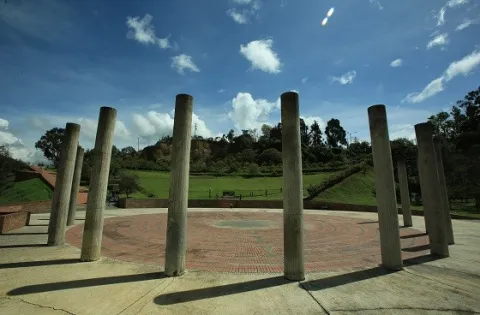 A circle of columns rises in the middle of Mirador de los Nevados Park, creating an open space for gathering and contemplating the natural landscape under Bogotá's blue sky.