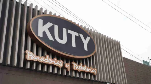 Acercamiento al letrero ovalado de Kuty Panaderías y Pastelerías en la fachada del establecimiento.