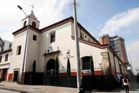 Fachada de la Iglesia de San Juan de Dios en Bogotá, con arquitectura colonial, torre campanario y entrada principal enmarcada en piedra.