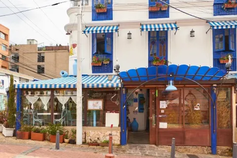 Fachada de Andrei en Usaquén, con arquitectura de estilo europeo, detalles en azul y blanco, ventanales decorados y terraza exterior.