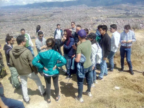 Grupo de personas realiza un recorrido turístico por las montañas de Ciudad Bolívar, con una vista panorámica de Bogotá al fondo.