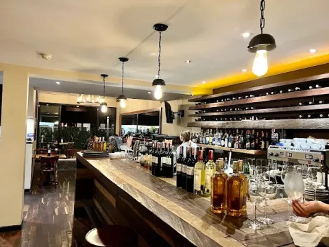 Interior de La Bifería, con barra de madera, vinos y un ambiente elegante y acogedor.