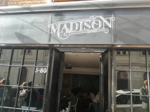 Fachada de Madison Bistro en Usaquén, con letrero del restaurante, amplios ventanales y acceso abierto al interior del establecimiento.