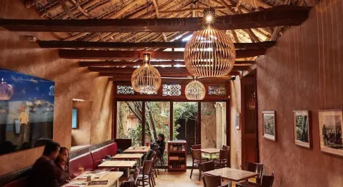 Interior de WOK, con una ambientación cálida de inspiración natural, techos de palma y detalles artesanales.