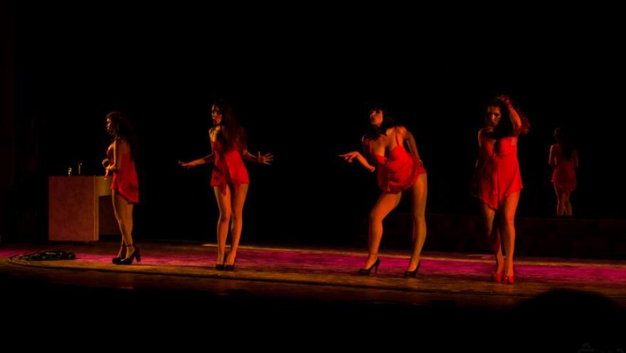 Barraca teatro con cuatro bailarinas jovenes vestidas de rojo en tarima.