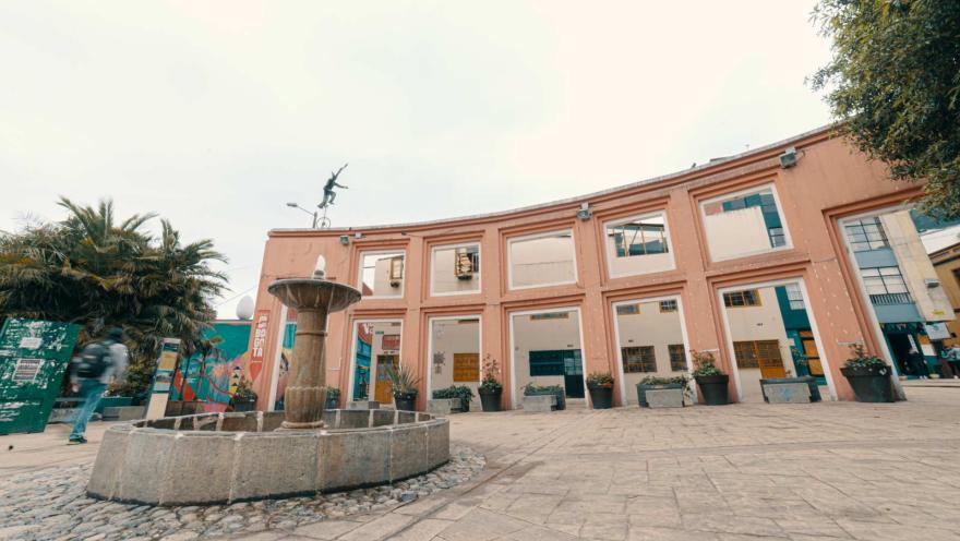 Plazoleta del Chorro de Quevedo plano general de la pila de agua y la pared gigantesta con una escultura encima de payaso en monociclo. 