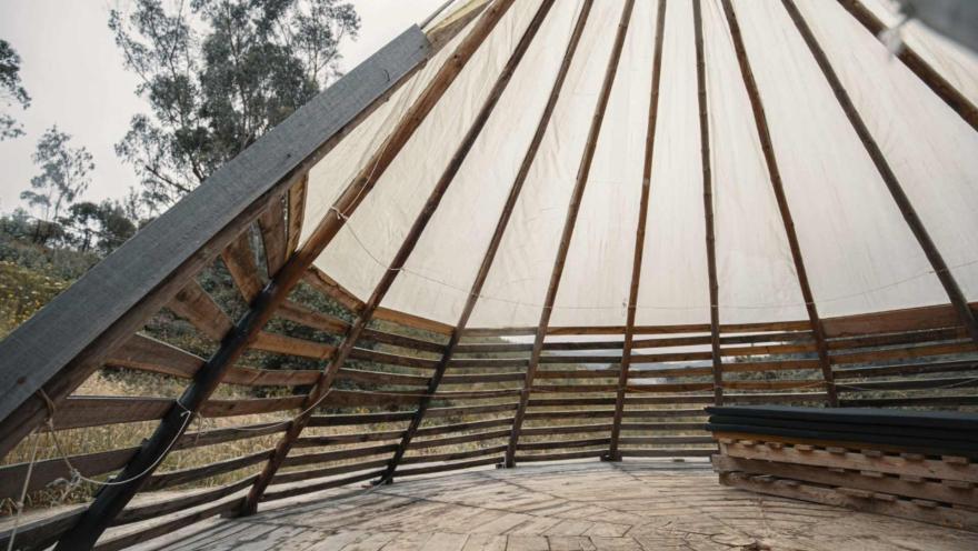  Páramo El Verjón con interior estructura piramidal de madera tipo maloka. Al fondo se observan algunos árboles altos.