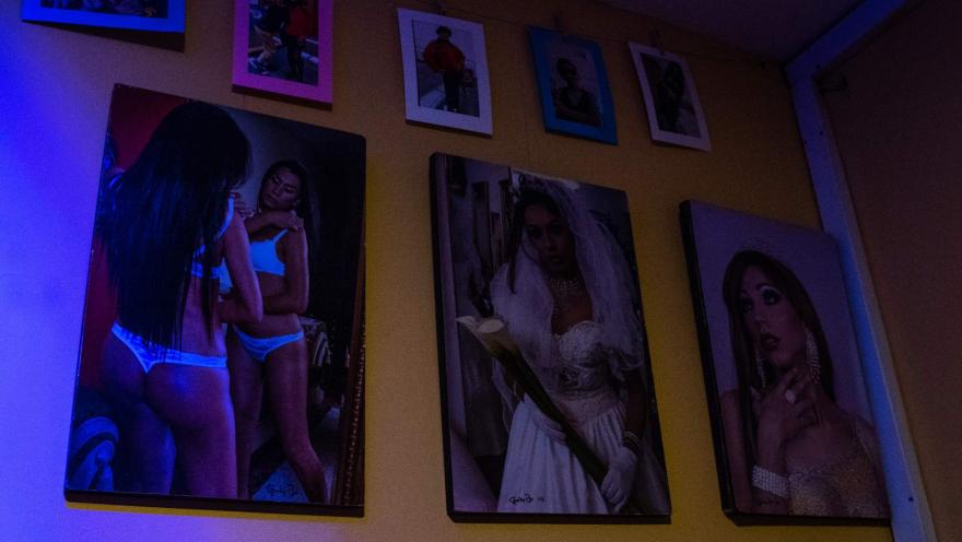 Museo Lgbti al interior fotografías colgadas en pared con cuerpos y rostros de personas trans. 
