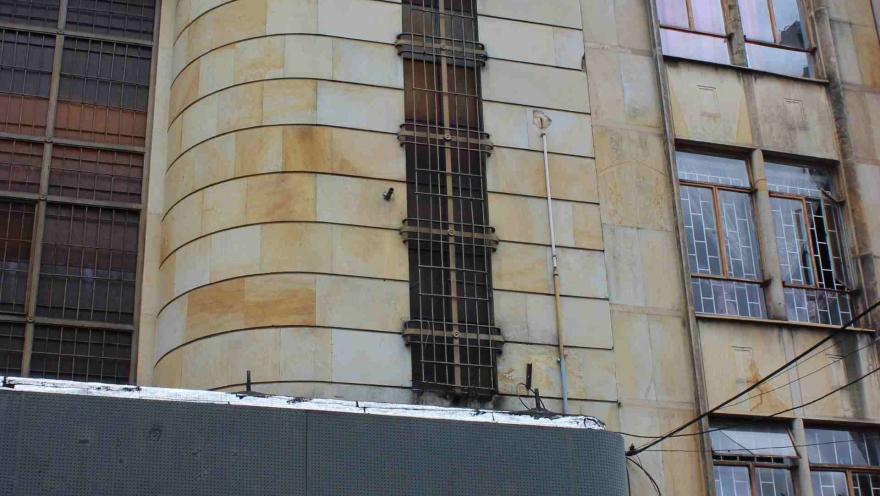  Auditorio Mayor fachada con un segundo piso en placas de piedra amarilla y ventanas cubiertas por rejas negras.