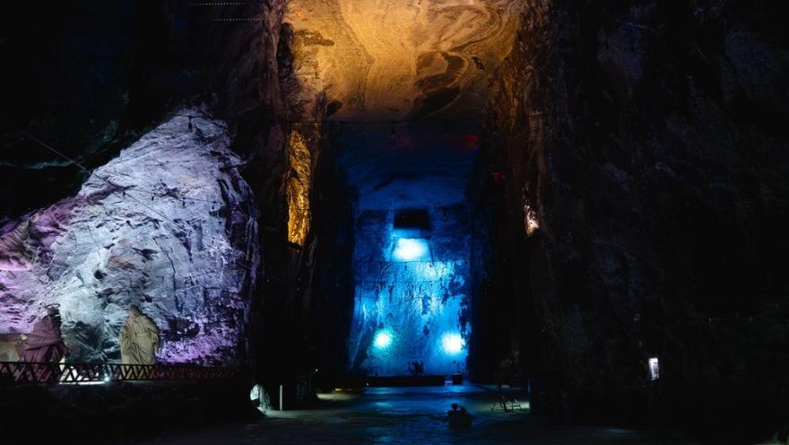 Catedral de Sal de Zipaquirá en caverna de gran altura con luces azul, violeta y amarillo.