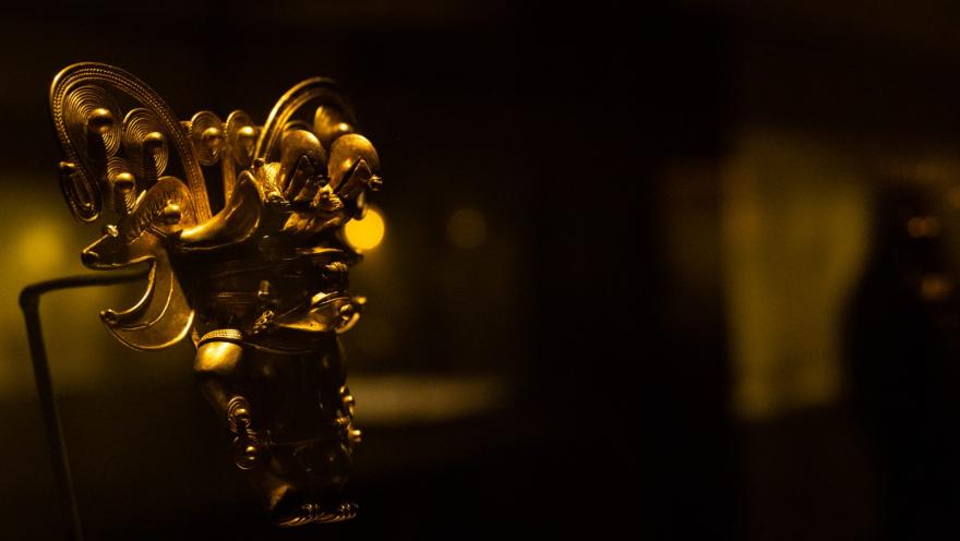 Museo del Oro con figura dorada que representa a un indigena pequeño con corona.