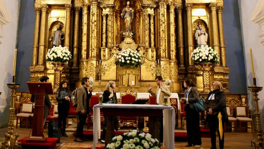 Iglesia San Ignacio vista interior del atrio con turistas y un guia.