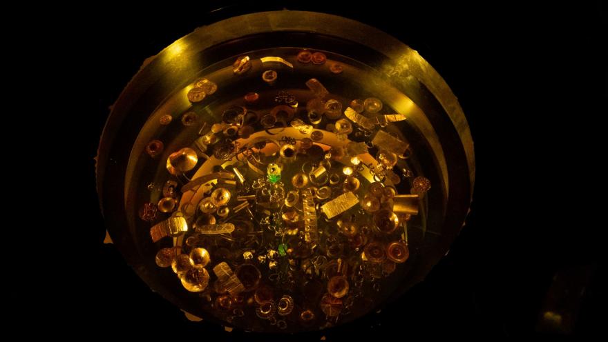 Museo del Oro con pieza de orfebrería en forma circular como un lato compuesto por elementos dorados y unas cuantas esmeraldas.