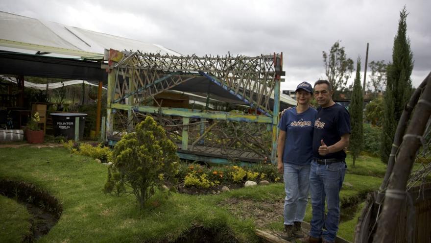 Pareja sonríe al frente de finca productora.