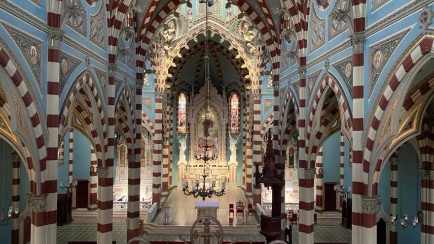  Santuario Nuestra Señora del Carmen al interior vista desde el segundo piso destacan las columnas y los arcos ovalados. Hay dos ventanas circulares a los lados por donde ingresa un leve haz de luz y una gigante lámpara cuelga del techo.