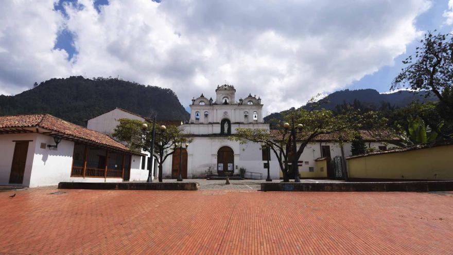 Plazoleta de la Iglesia colonial de las Aguas de día con los cerros orientales de fondo.
