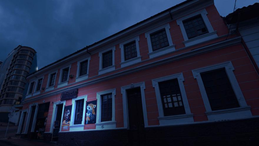 Casa de fachada rosa en La Candelaria con tono azul de anochecer.