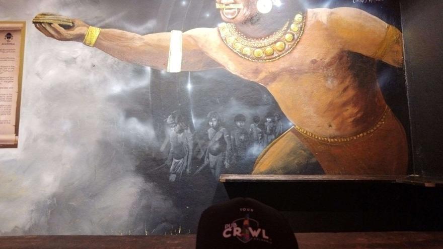 Un mural con unos indigenas jugando tejo. 