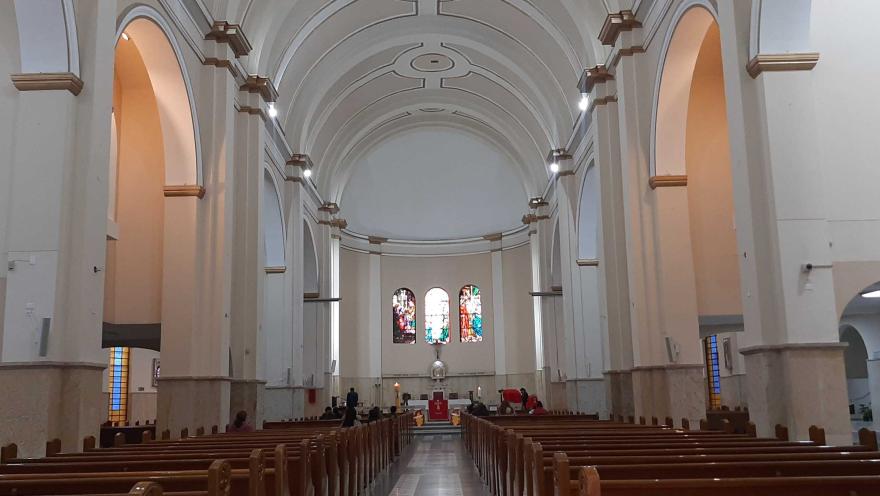 La Iglesia Nuestra Señora de la Valvanera por dentro con sus grandes torres en arcos y techo en forma de óvalos. al fondo se ve el atrio y tres ventanas en óvalos con vitrales.