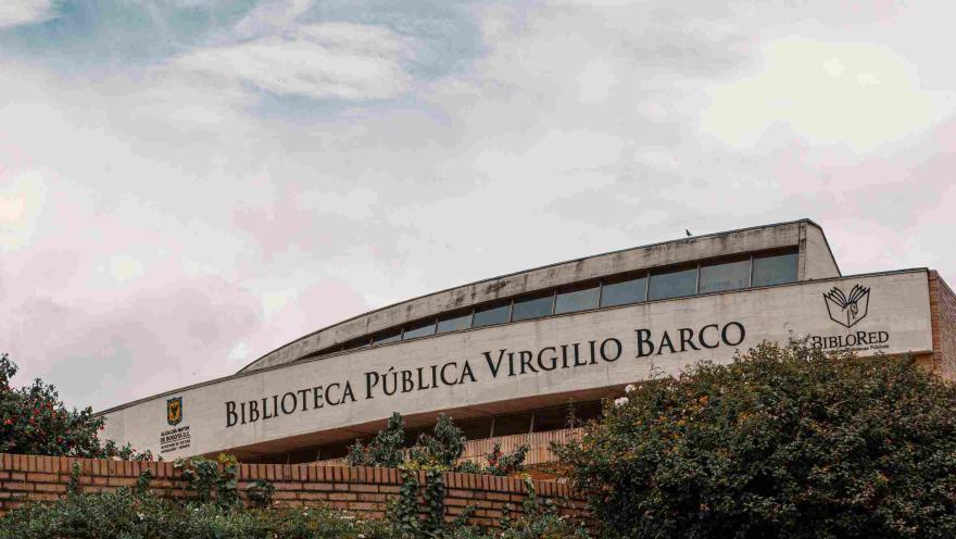 Fachada en ladrillo y piedra en la que resalta el nombre de la Biblioteca Virgilio Barco. El cielo es gris.