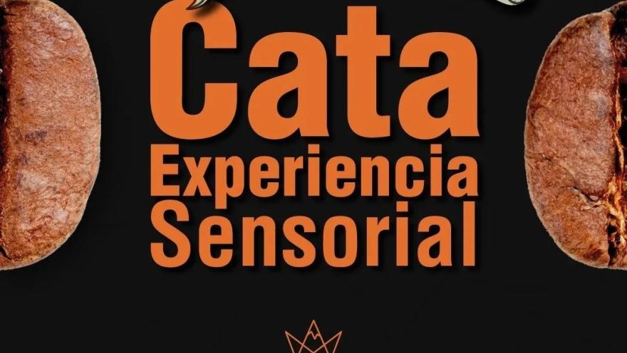 Un aviso fondo negro con letras grandes y naranjas que dice Cata Experencia Sesorial. Hay medio trozo de café en cada lado del aviso.