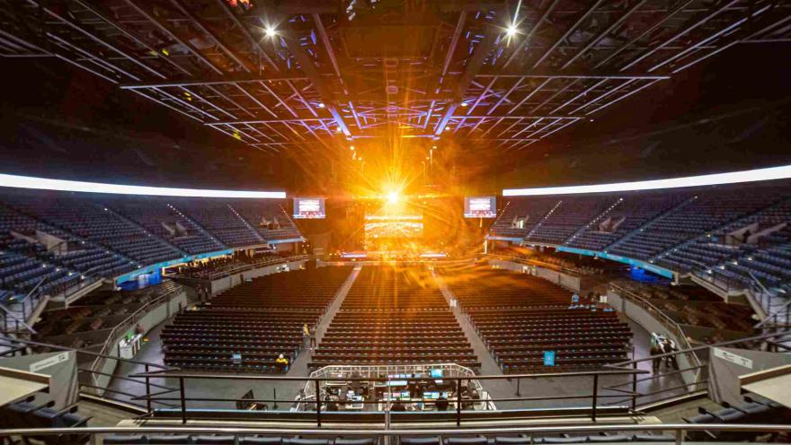  Escenario interno en el que se ven tribunas desocupadas y un haz de luz brillante dorada que viene desde la tarima.