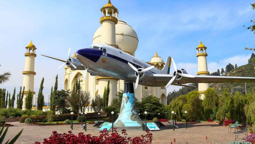 Monumento del Taj Mahal con un pequeño avión sostenido en una estructura de concreto.