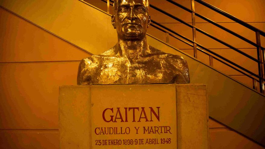 Busto dorado en bronce con la imagen de Jorge Eliecer Gaitán. LLeva tallados el citado nombre, la frase "Caudillo y Martir"  y la fecha de su nacimiento y muerte.