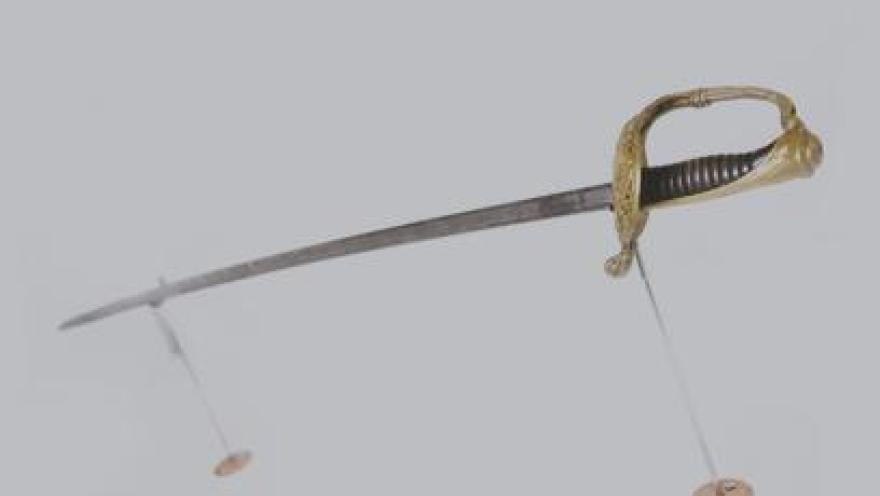  Espada con un asta dorada.