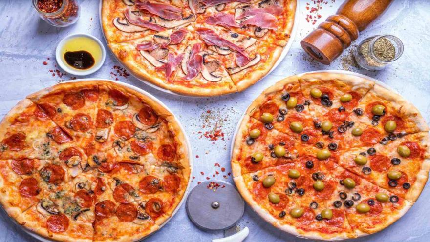 Tres pizzas artesanales con distintos ingredientes: champiñones y jamón, pepperoni, y aceitunas