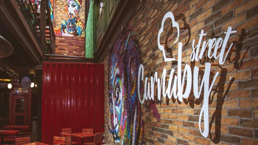 Pared de ladrillo con un vibrante mural de estilo graffiti y el letrero "Carnaby Street" iluminado.