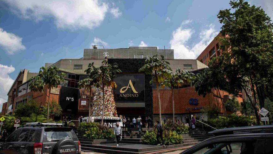 Fachada del Centro Comercial Andino en ladrillo. Al frente hay un árbol de Navidad y varias personas y árboles alrededor.