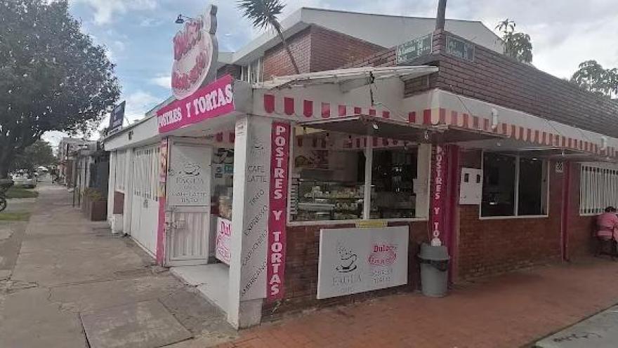 Fachada de local comercial en ladrillo donde sobresale un aviso con una leyenda que dice: "Postres y tortas".