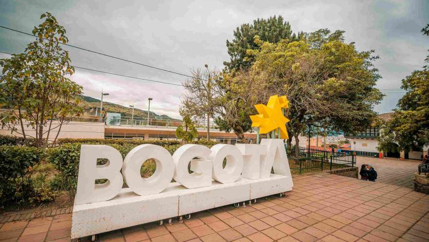 A large white sign with the word Bogotá, with yellow stars above the letter “A.”