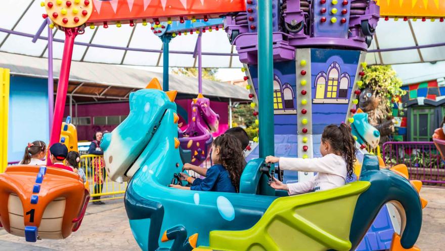 Un par de niños en una atracción mecánica en movimiento.