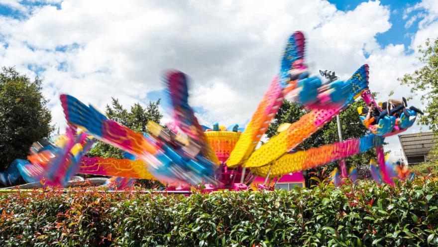 Atracción mecánica como una araña gigante de colores vivos en movimiento a gran velocidad..