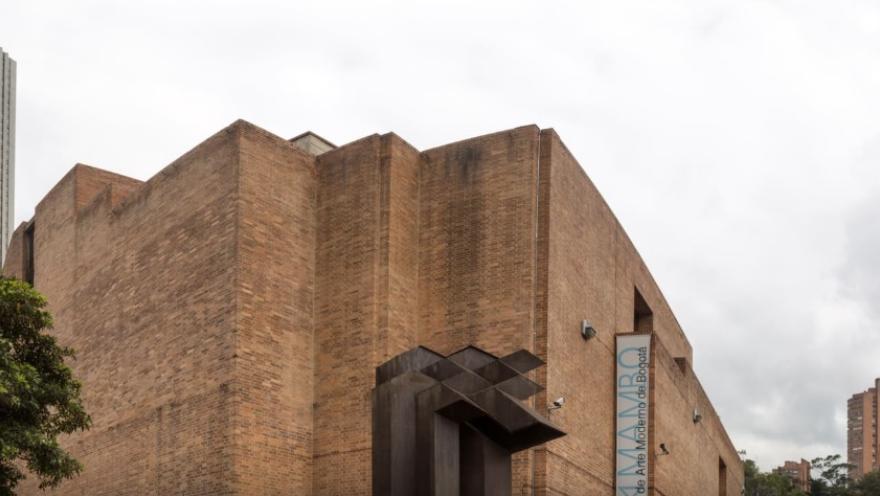 Fachada de gran edificio en ladrillo donde sobresale un aviso con una leyenda en letras azules que dice: “MAMBO”.