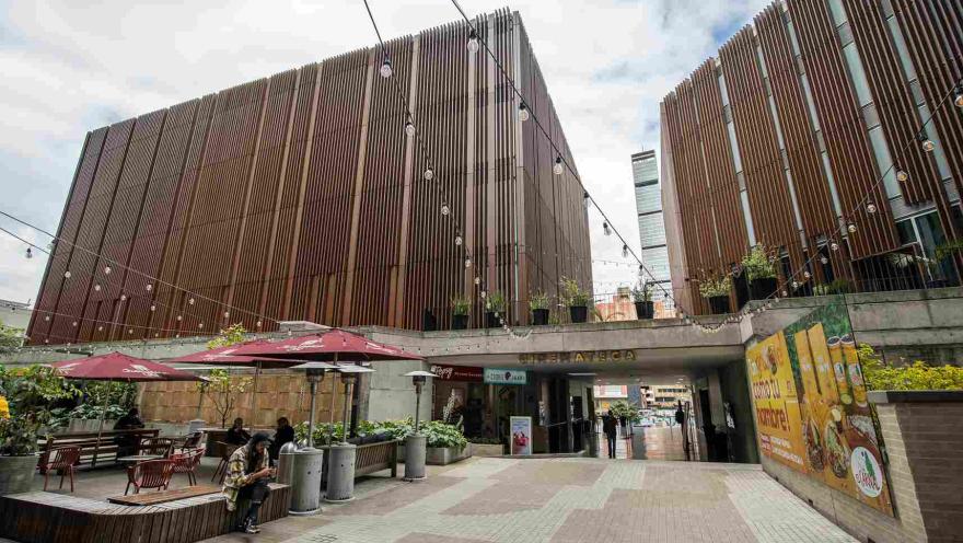 Gran estructura entre madera y concreto con una puerta principal en la que destaca un aviso en bronce con una leyenda que dice: “Cinemateca”.