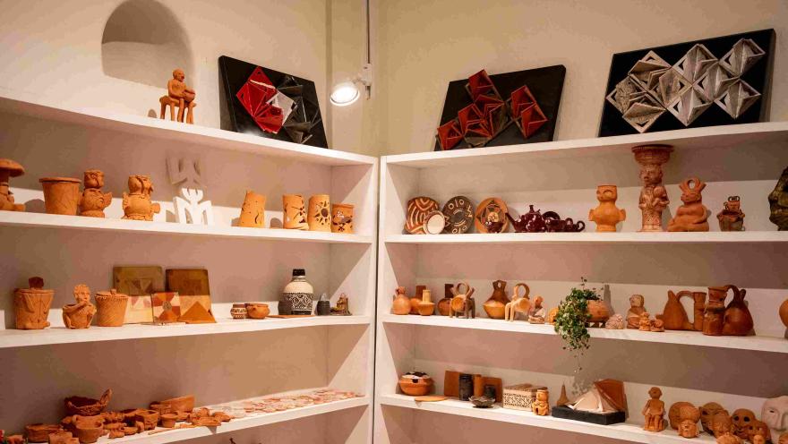  Estantería en madera con una gran colección de objetos de cerámica, de diferentes tamaños y formas. 