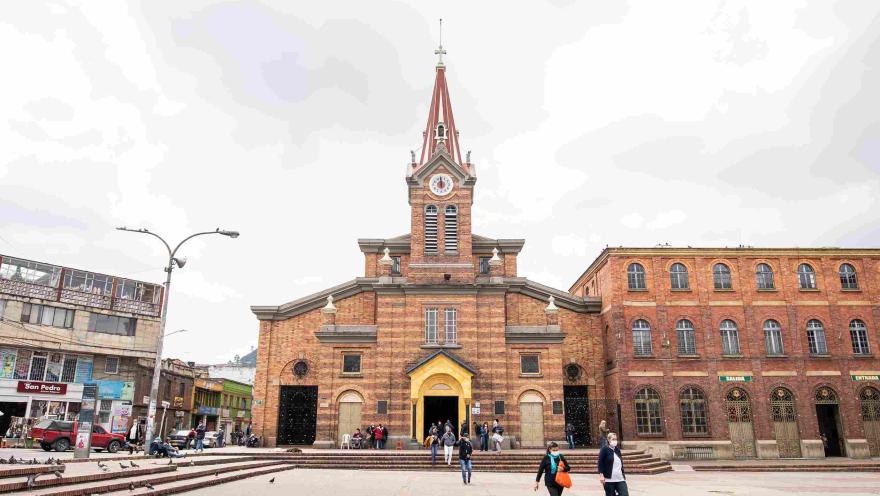 Plano general de la fachada de la iglesia del Divino Niño en ladrillo. Destaca su torre central con reloj y campanario.